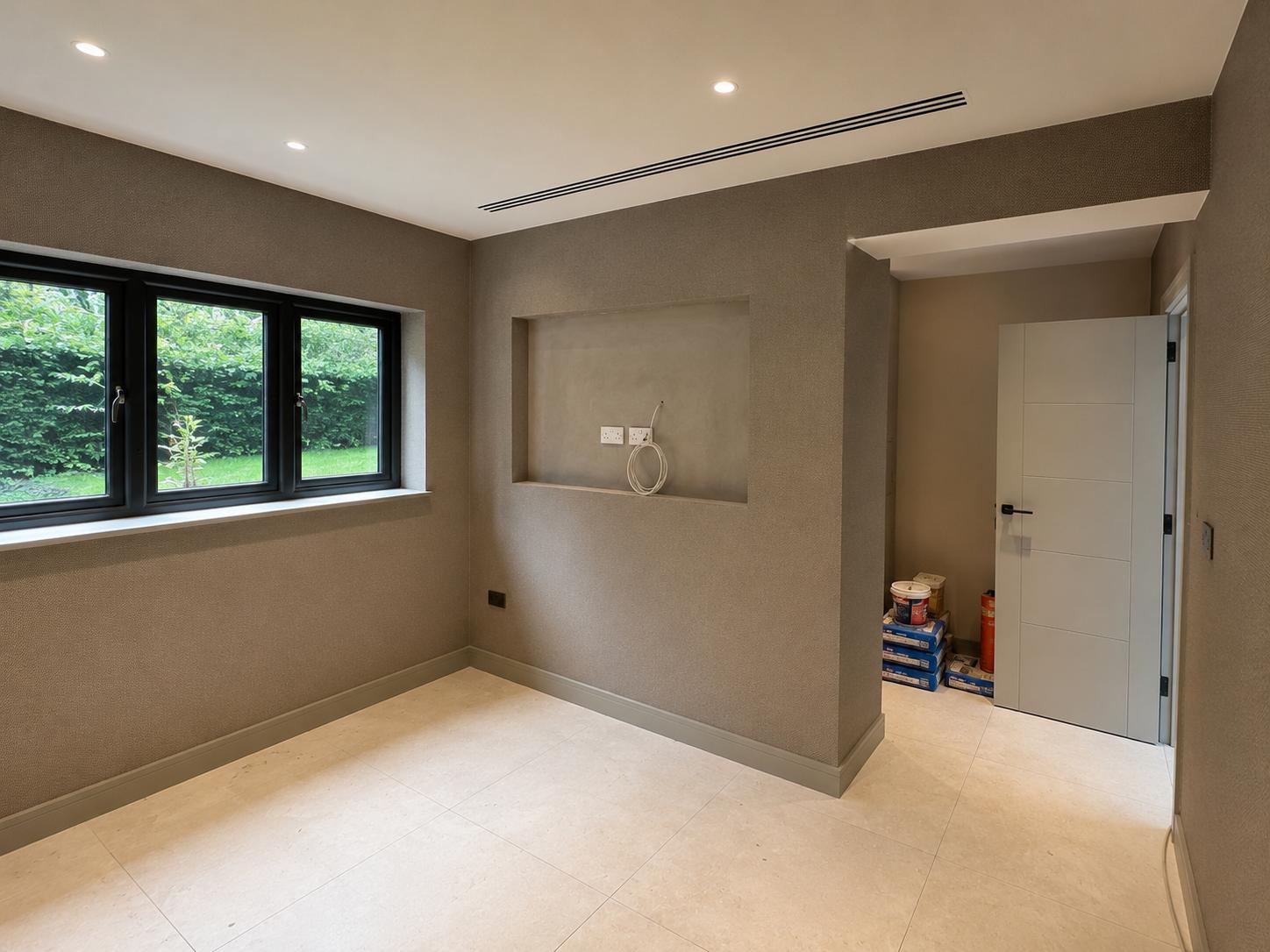 Bedroom with textured grey walls and a large window