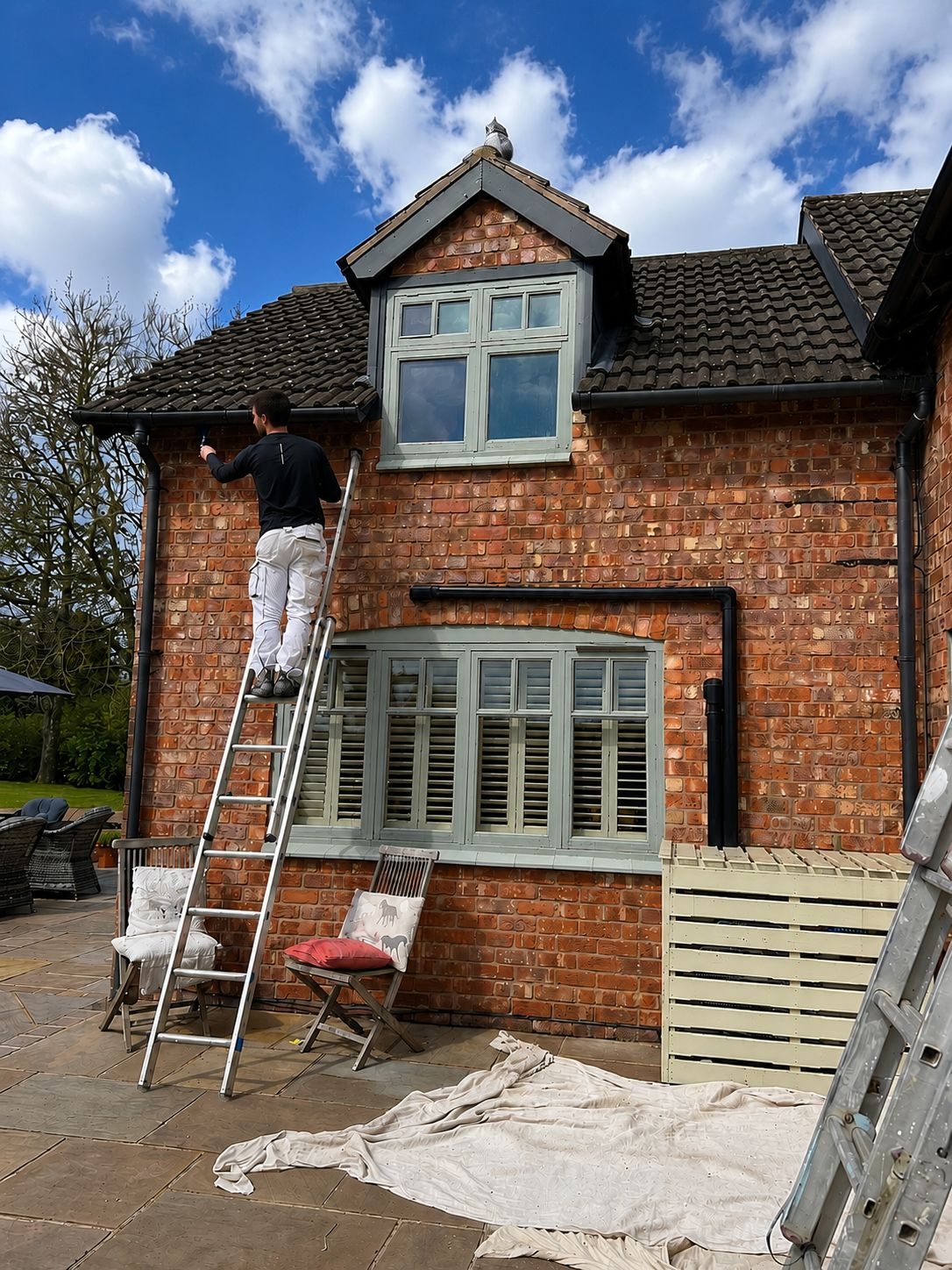 AYM Decor painting the windows of a brick house
